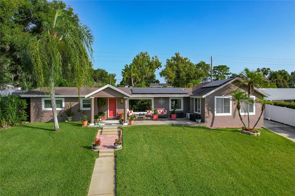 An aerial view shows several houses with swimming pools situated along the shore of a lake — 128 N LAKE FLORENCE DRIVE, WINTER HAVEN, FL