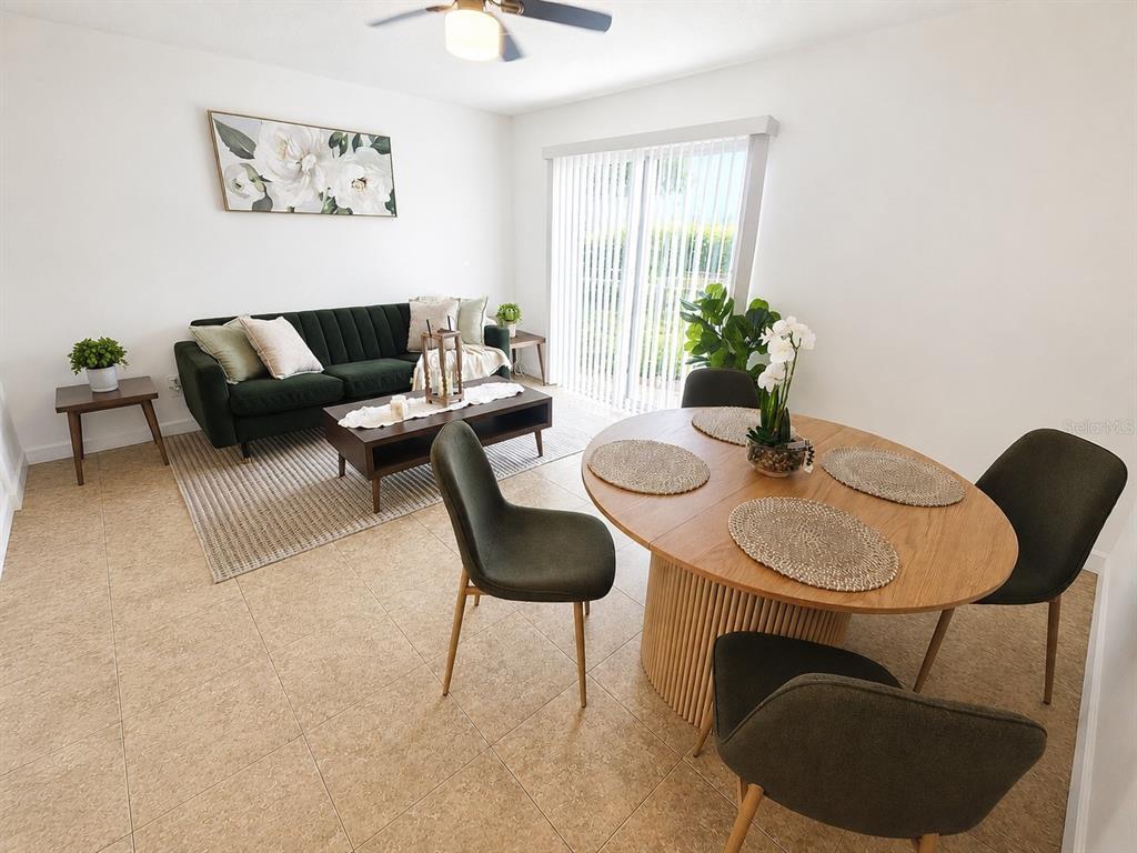 A living and dining area features a green sofa, wooden table, and tile flooring — 5820 N CHURCH AVENUE UNIT 112, TAMPA, FL