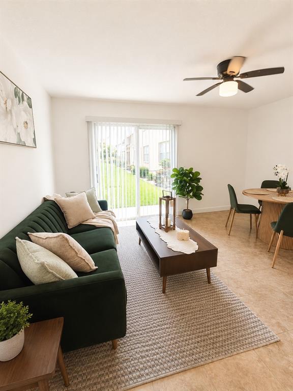 A living and dining area features a green sofa, coffee table, and sliding glass door — 5820 N CHURCH AVENUE UNIT 112, TAMPA, FL