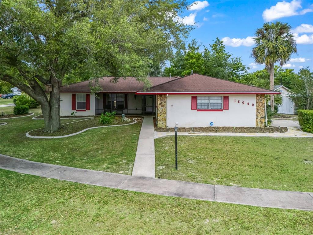 A single-story house with a white stucco facade, red shutters, and a brown roof — 15090 SW 35TH CIRCLE, OCALA, FL