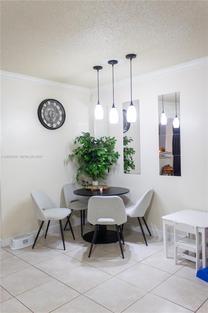 A dining area features a round table, four chairs, pendant lighting, and wall mirrors — 7645 NW 38th Ct, Sunrise FL 33351, SUNRISE, FL