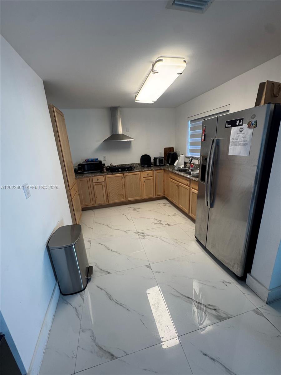A kitchen features light wood cabinets, granite countertops, stainless steel appliances, and white marble-patterned tile floors — 14017 SW 160th Ter, Miami FL 33177, MIAMI, FL