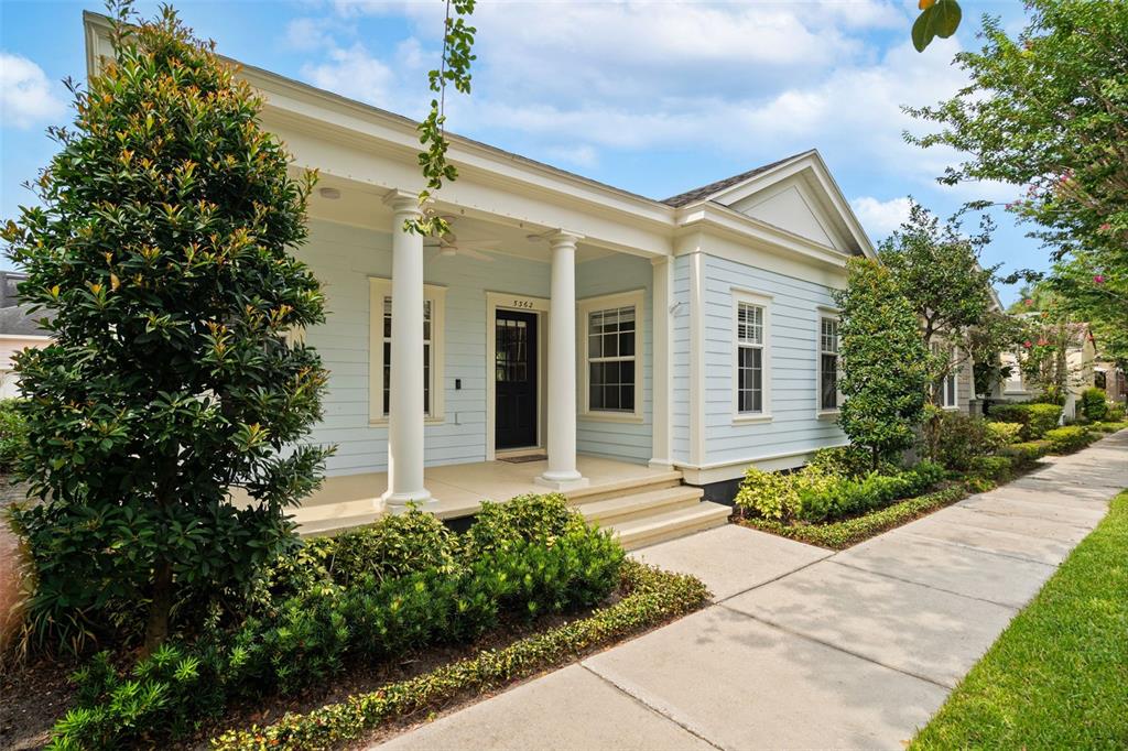 A light blue house with a front porch, white columns, and a black front door — 5362 CHATAS LANE, ORLANDO, FL