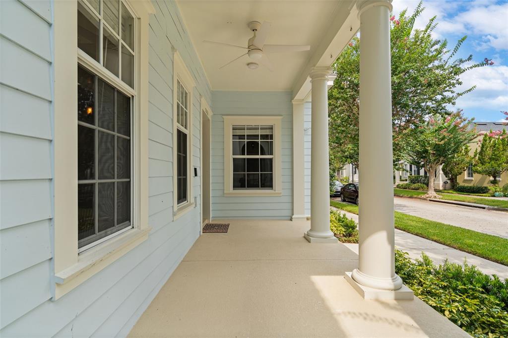 A covered front porch with light blue siding, white columns, and a ceiling fan — 5362 CHATAS LANE, ORLANDO, FL