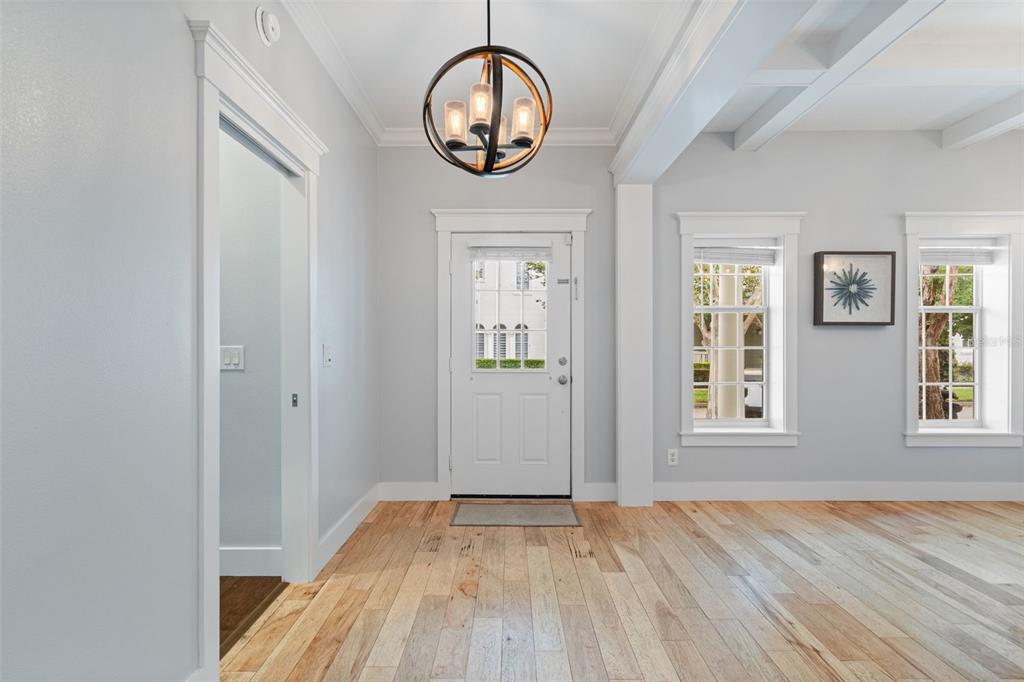 An entryway features light gray walls, hardwood floors, a globe pendant light, and a white door — 5362 CHATAS LANE, ORLANDO, FL