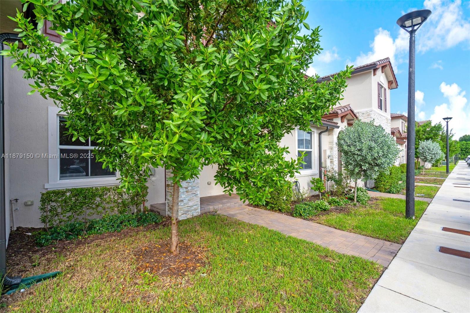 A paved walkway leads to the entrance of a two-story house with a front lawn — 2357 NW 122nd Ter, Miami FL 33167, MIAMI, FL