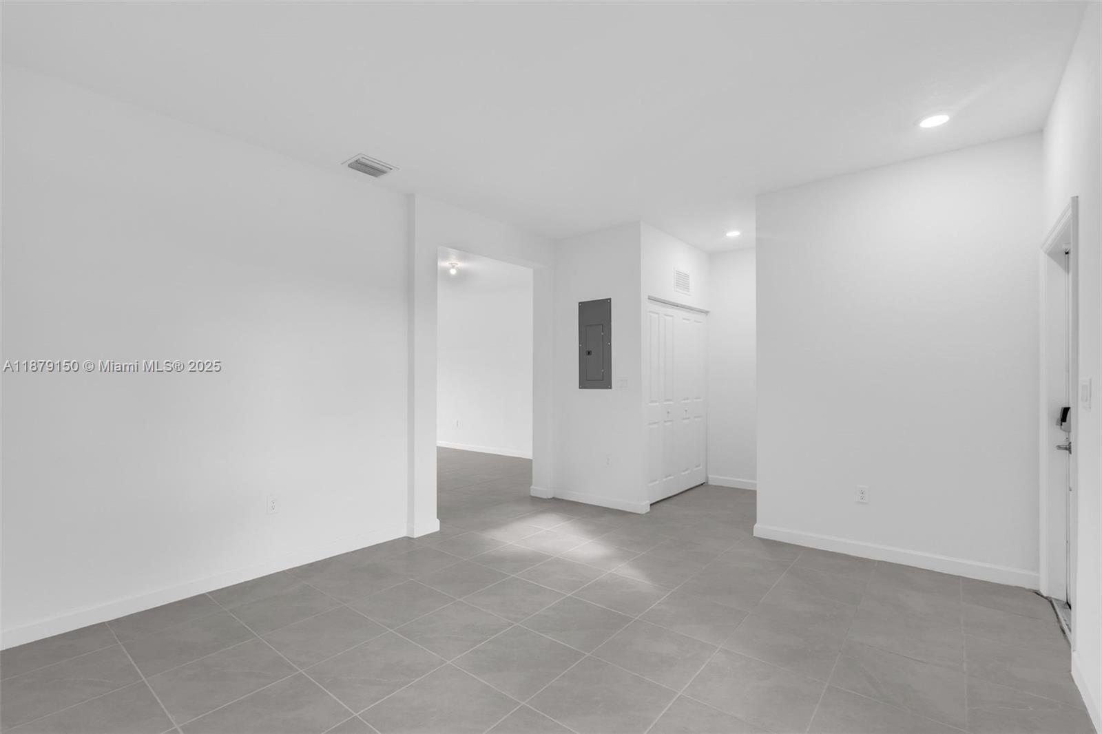 A minimalist room features gray tile flooring, white walls, and a closed closet door — 2357 NW 122nd Ter, Miami FL 33167, MIAMI, FL
