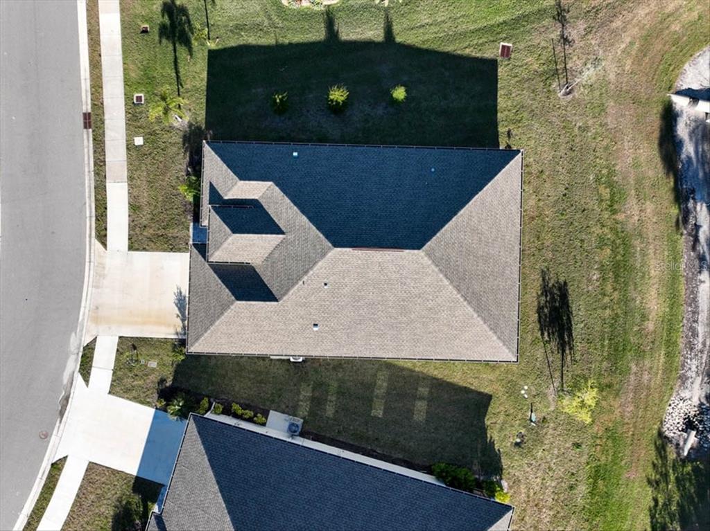 An aerial view shows the roof of a house and its surrounding yard and driveway — 725 REDBUD COURT, ENGLEWOOD, FL