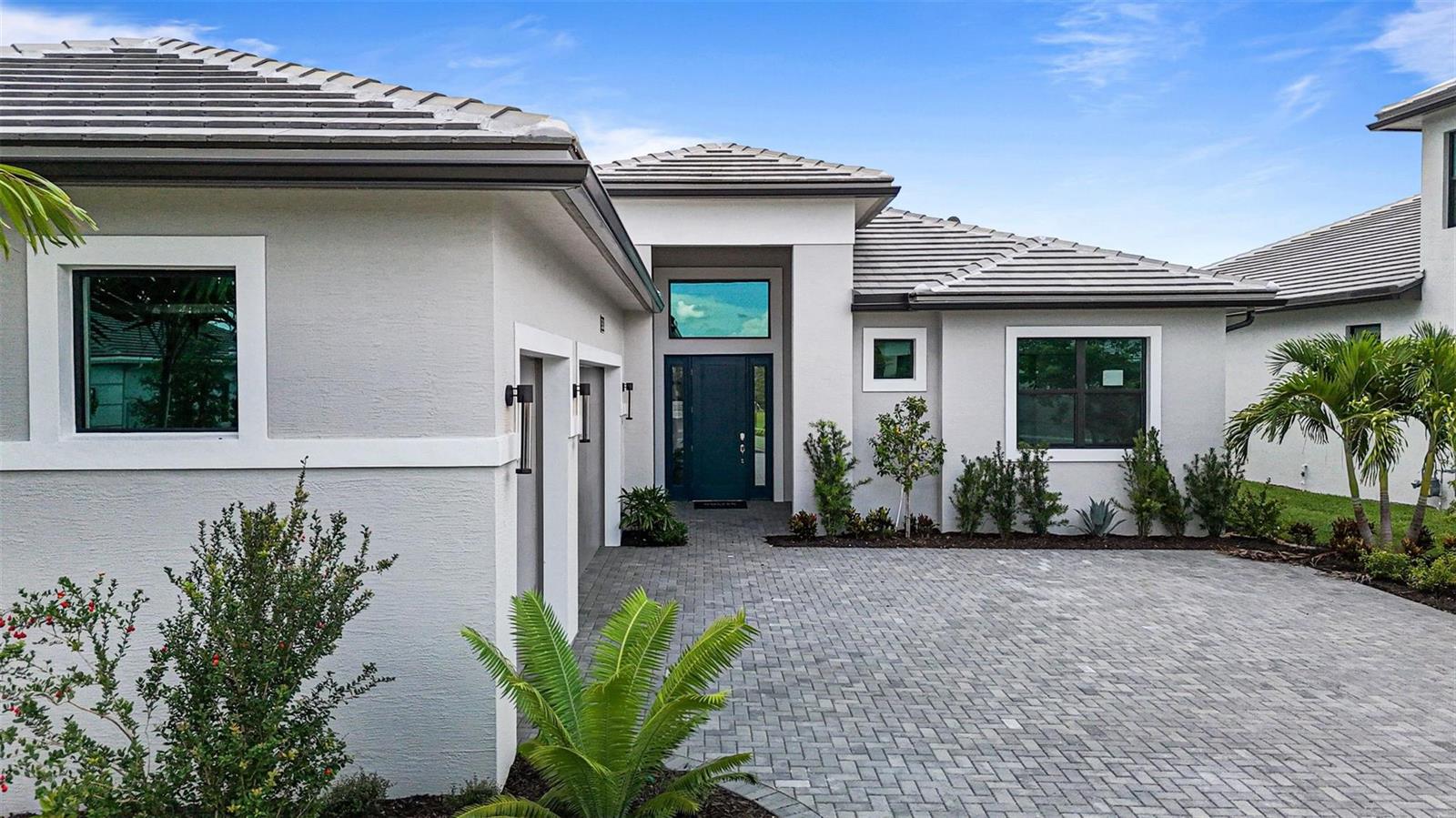 A single-story house with a gray tiled roof, stucco exterior, and a paved driveway — 5303 Saint Armands Way, Westlake FL 33470, WESTLAKE, FL