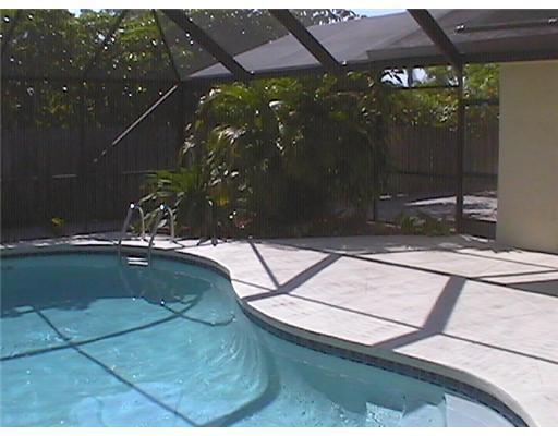 A swimming pool with a metal screen enclosure and a concrete patio area — 6050 Amberwoods Drive, Boca Raton FL 33433, BOCA RATON, FL
