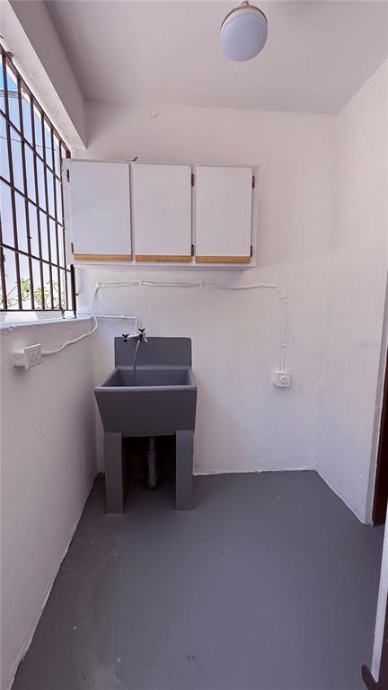 A utility room features a grey floor, a wall-mounted sink, and white overhead cabinets — RIO PIEDRAS URB. GARCIA UBARRI APT 1A, SAN JUAN, PR