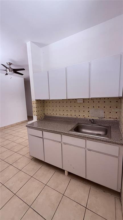 A kitchen features white cabinets, a speckled countertop, a stainless steel sink, and tiled walls — RIO PIEDRAS URB. GARCIA UBARRI APT 1A, SAN JUAN, PR