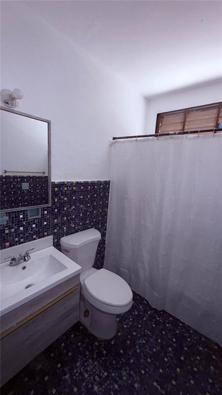 A bathroom features a white vanity, a toilet, and a shower with a white curtain — RIO PIEDRAS URB. GARCIA UBARRI APT 1A, SAN JUAN, PR