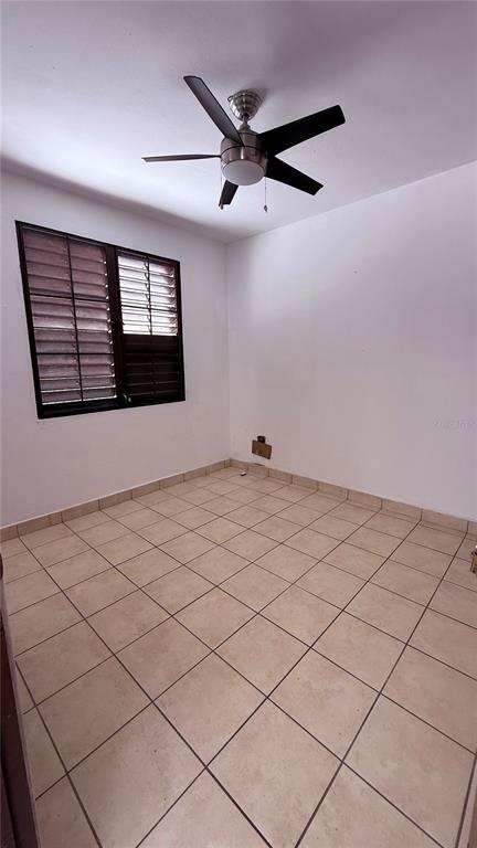 An empty room with beige tile flooring, white walls, and a ceiling fan — RIO PIEDRAS URB. GARCIA UBARRI APT 1A, SAN JUAN, PR