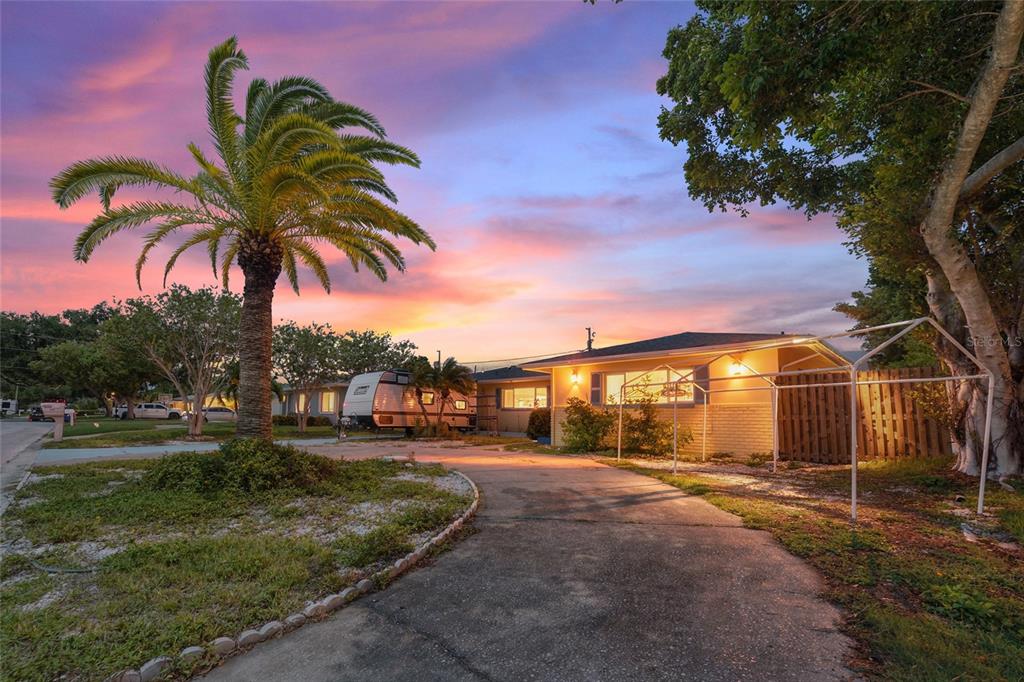 A single-story house with a palm tree, a driveway, and a camper parked outside — 9735 50TH AVENUE N, MADEIRA BEACH, FL