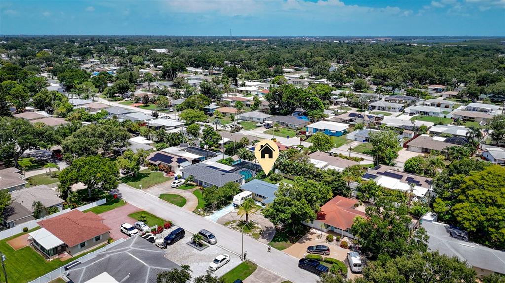 An aerial view shows a residential neighborhood with a house marked by a location icon — 9735 50TH AVENUE N, MADEIRA BEACH, FL