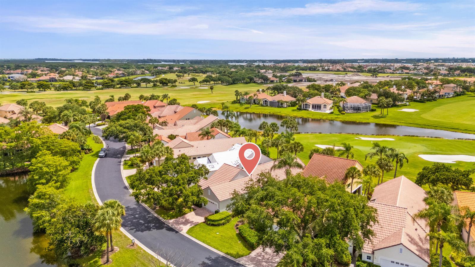 An aerial view shows a residential neighborhood with houses, a golf course, and a lake — 1753 Victoria Circle, Vero Beach FL 32967, VERO BEACH, FL