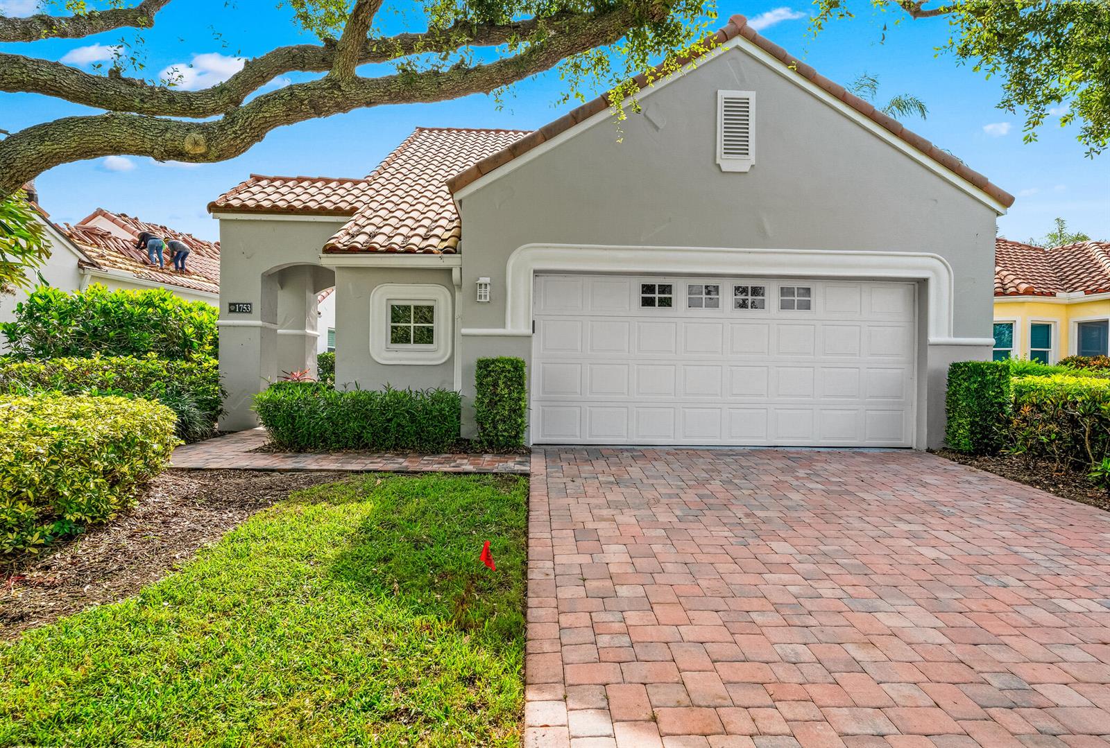 A single-story house with a tiled roof, gray stucco exterior, and a brick paver driveway — 1753 Victoria Circle, Vero Beach FL 32967, VERO BEACH, FL