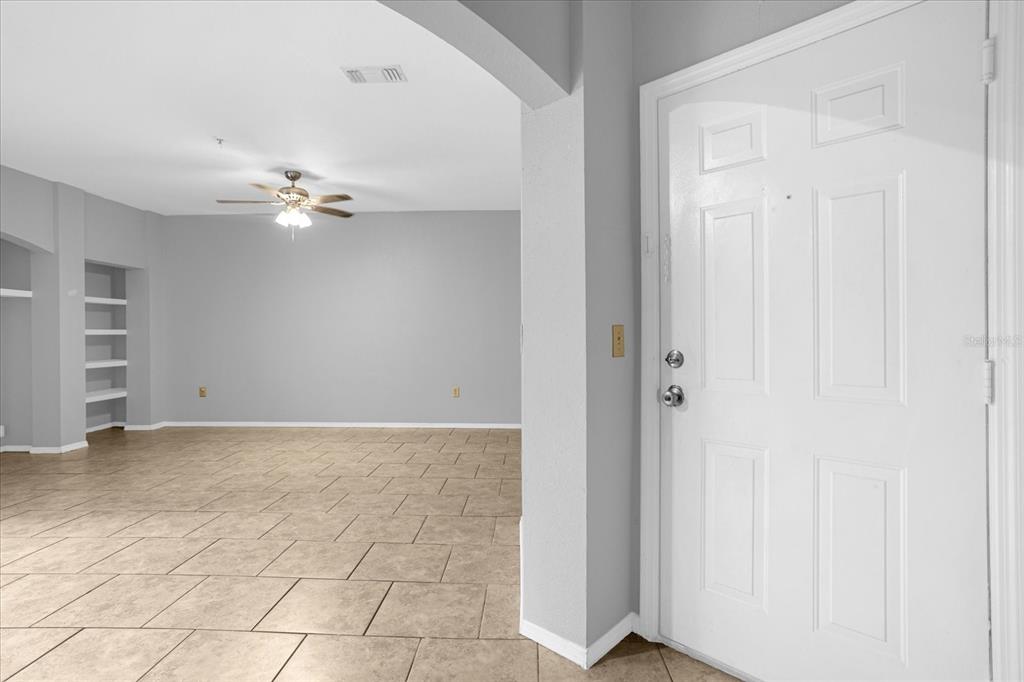 A white front door opens into a tiled living area with a ceiling fan — 1341 ARBOR VISTA LOOP UNIT 205, LAKE MARY, FL