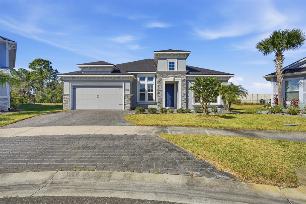 A single-story house with a gray garage, stone accents, and a blue front door — 6200 W FALLSGROVE LANE, PORT ORANGE, FL