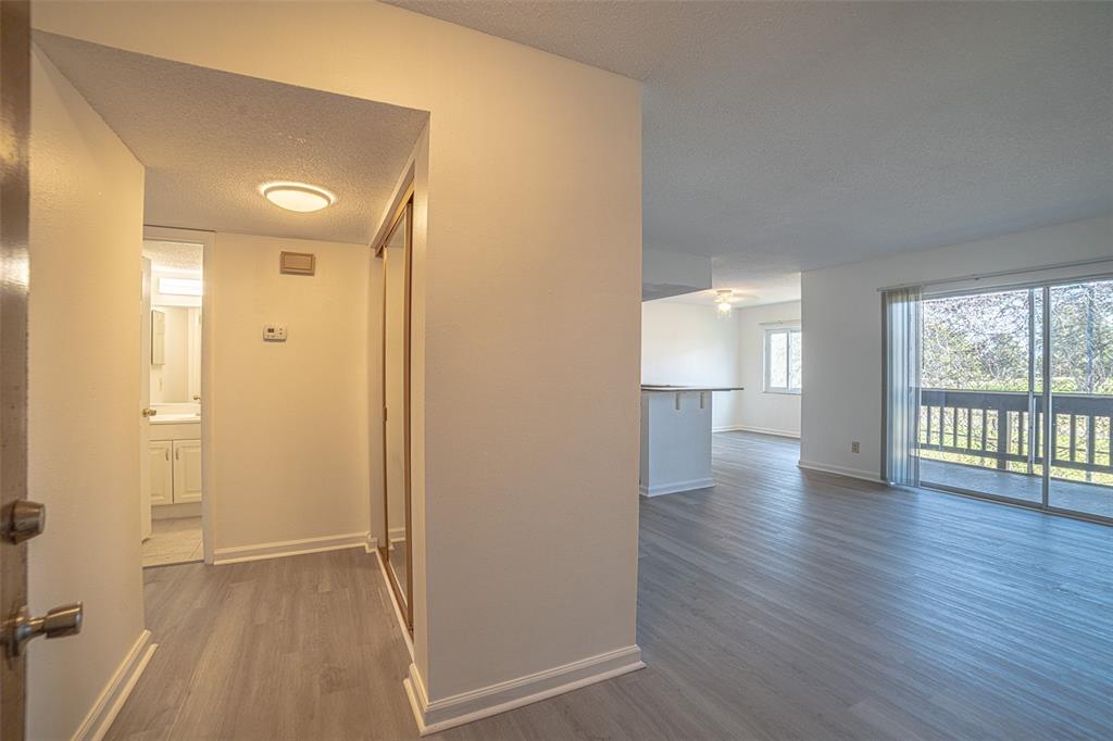 An entryway with a closet leads to an open living area with sliding glass doors — 629 N KEENE ROAD UNIT T11, CLEARWATER, FL