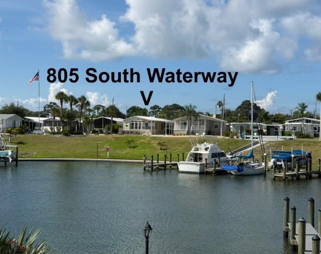 A waterfront view shows several mobile homes along a grassy bank with docked boats — 805 S WATERWAY, VENICE, FL