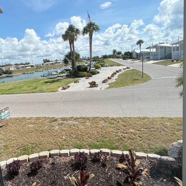 An outdoor view shows a landscaped garden bed, a paved street, and a waterfront area — 805 S WATERWAY, VENICE, FL