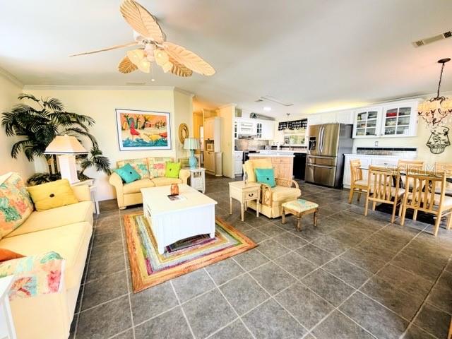 A living room with tile floors, a ceiling fan, and a view of the kitchen — 805 S WATERWAY, VENICE, FL