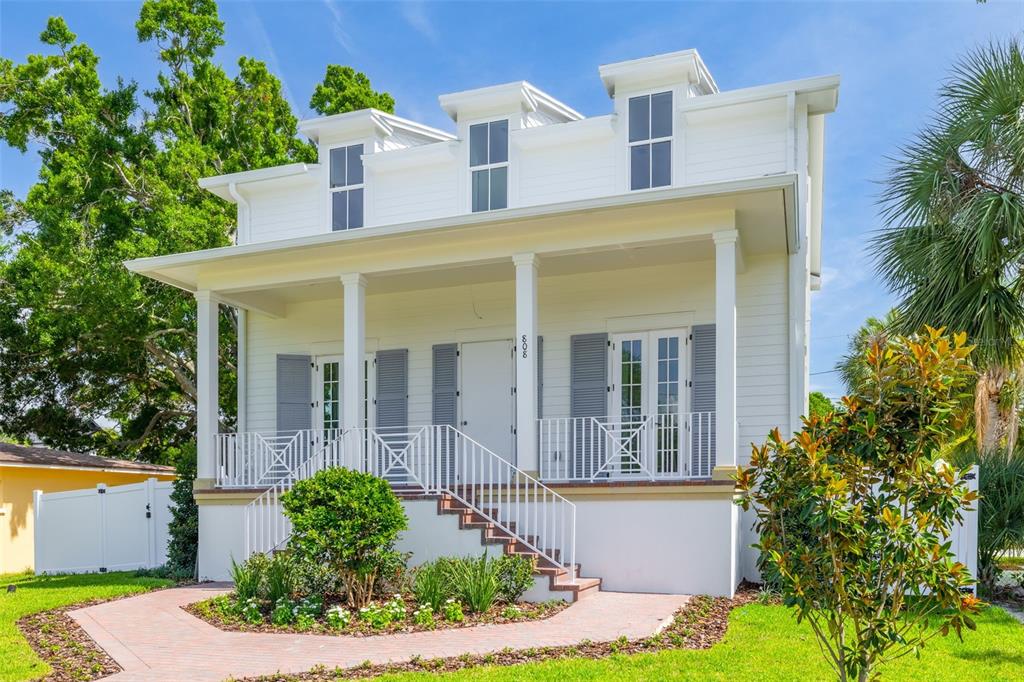 A white two-story house with a front porch, dormer windows, and a brick walkway — 808 39TH AVENUE NE, ST PETERSBURG, FL
