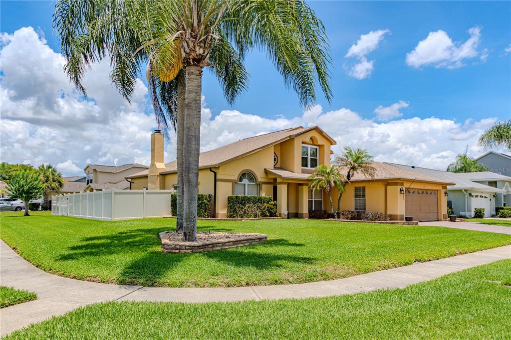 A two-story yellow house with a palm tree in the front yard — 3849 OCITA DRIVE, ORLANDO, FL