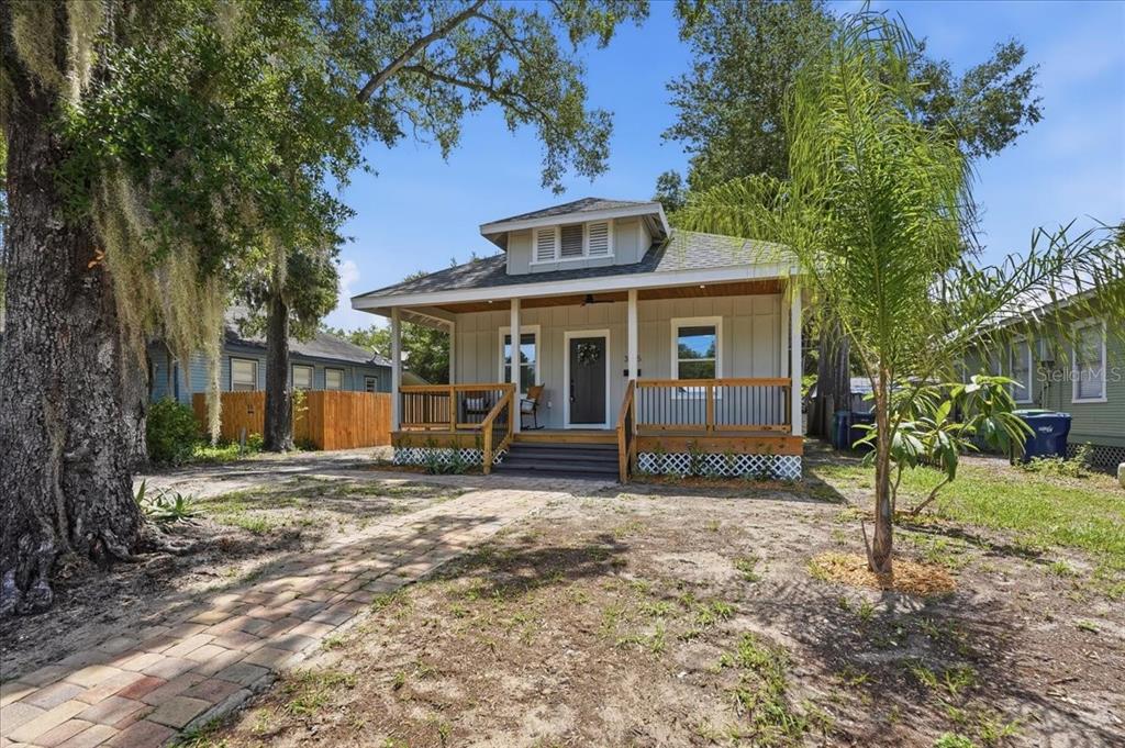 A covered wooden porch features two rocking chairs on a patterned rug — 3705 N HIGHLAND AVENUE, TAMPA, FL
