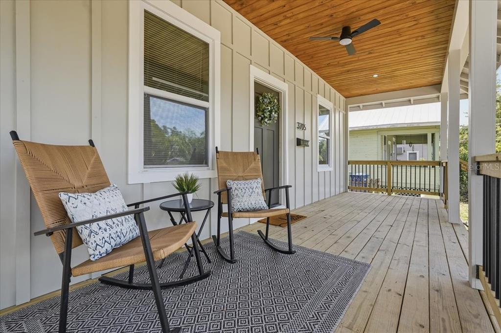 A living room features a fireplace, a sofa, a glass coffee table, and white walls — 3705 N HIGHLAND AVENUE, TAMPA, FL
