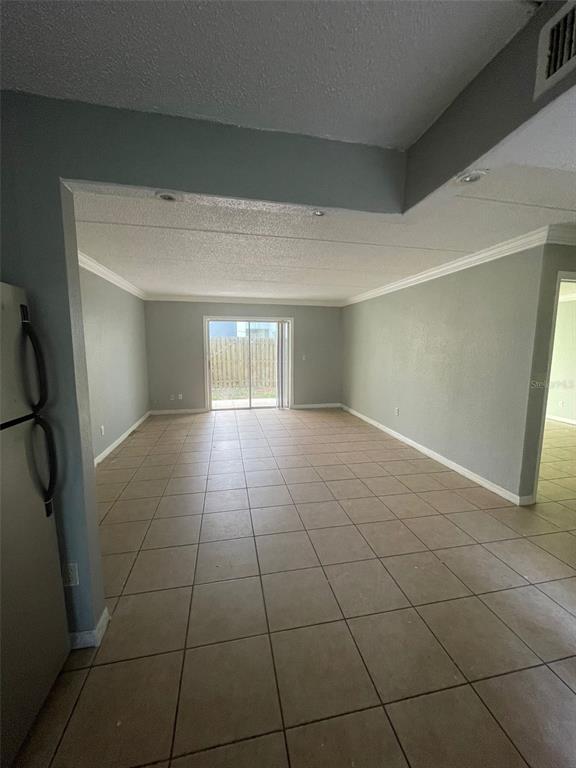 An open-concept living area features light gray walls, tiled flooring, and a sliding glass door — 14413 AMERICANA CIRCLE UNIT 105, TAMPA, FL