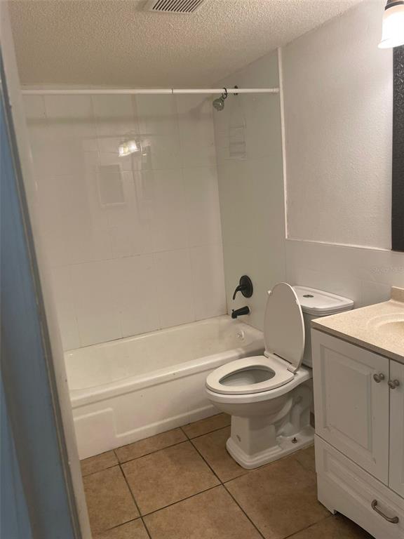 A bathroom featuring a white bathtub, a toilet, and a vanity with a beige countertop — 14413 AMERICANA CIRCLE UNIT 105, TAMPA, FL