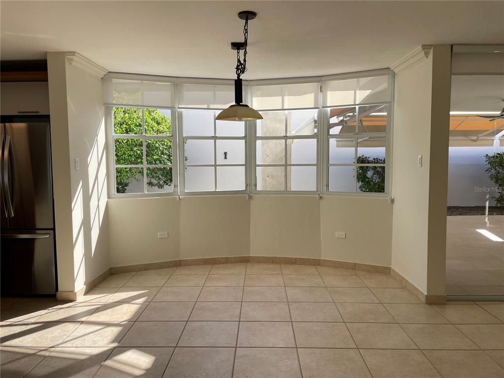 A bright dining area features tiled floors, a bay window, and a hanging pendant light — Palma Real COCO PLUMOSA, GUAYNABO, PR