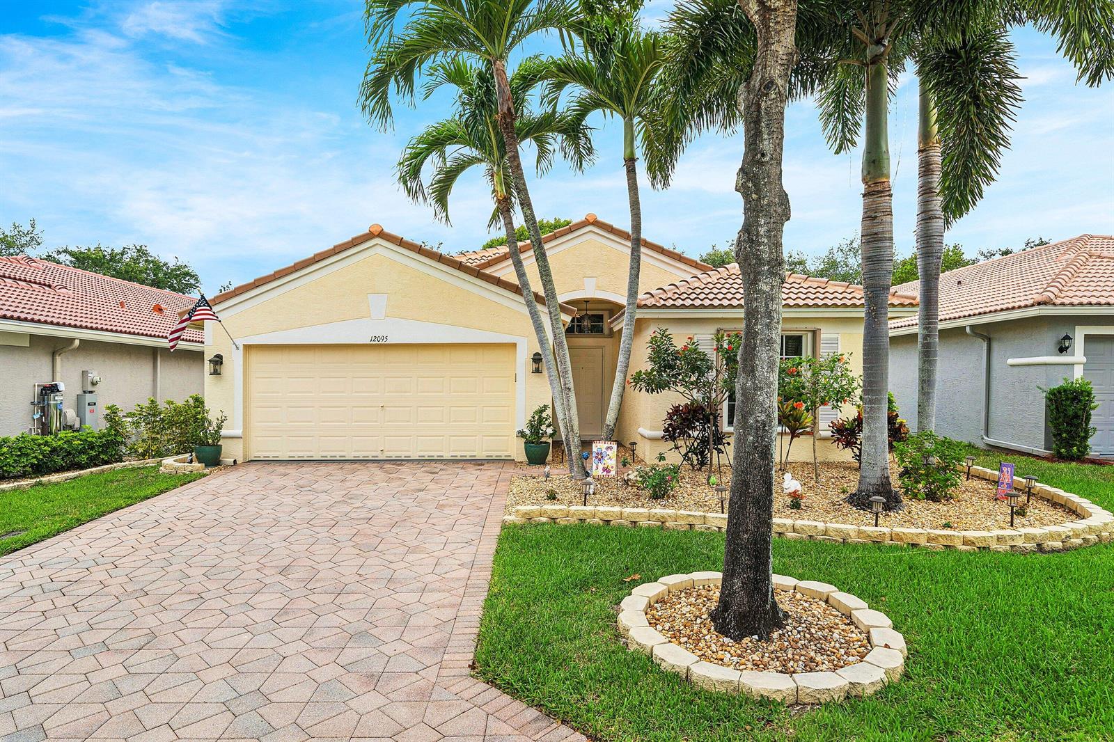 A single-story house with a paved driveway, a two-car garage, and palm trees in front — 12095 Roma Road, Boynton Beach FL 33437, BOYNTON BEACH, FL