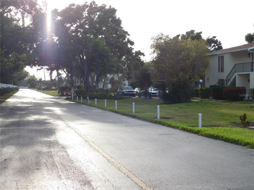 A paved road runs alongside a grassy area with white posts and apartment buildings — 5400 34TH STREET W UNIT L5, BRADENTON, FL