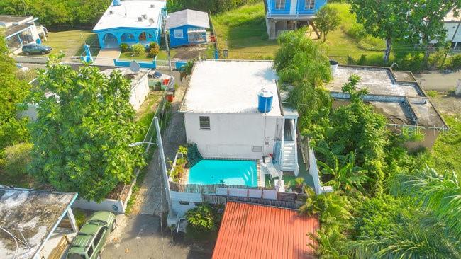 An aerial view shows a white house with a backyard swimming pool and surrounding greenery — PELICAN ESTATE-PUNTAS- CARR 413 KM 3.3, RINCON, PR