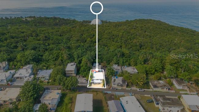 An aerial view shows a house highlighted with a white outline near a coastal forest — PELICAN ESTATE-PUNTAS- CARR 413 KM 3.3, RINCON, PR