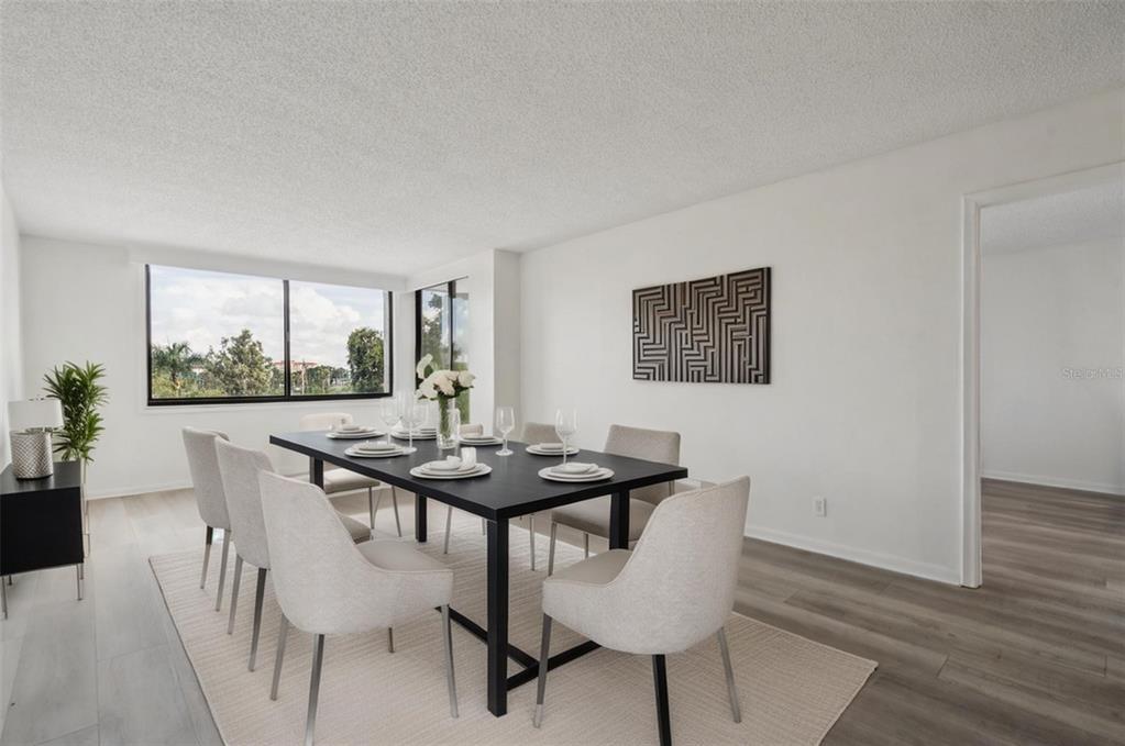A dining room features a black table, six light-colored chairs, and a large window — 6219 PALMA DEL MAR BOULEVARD S UNIT 301, ST PETERSBURG, FL