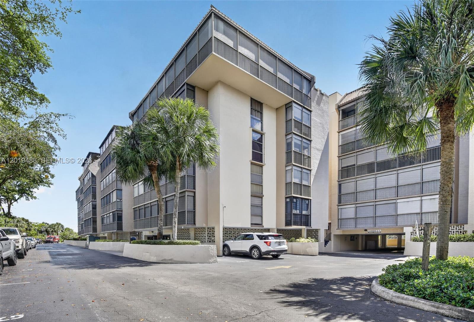 A multi-story apartment building with screened balconies and a ground-level parking area — 2808 N 46th Ave # E654, Hollywood FL 33021, HOLLYWOOD, FL
