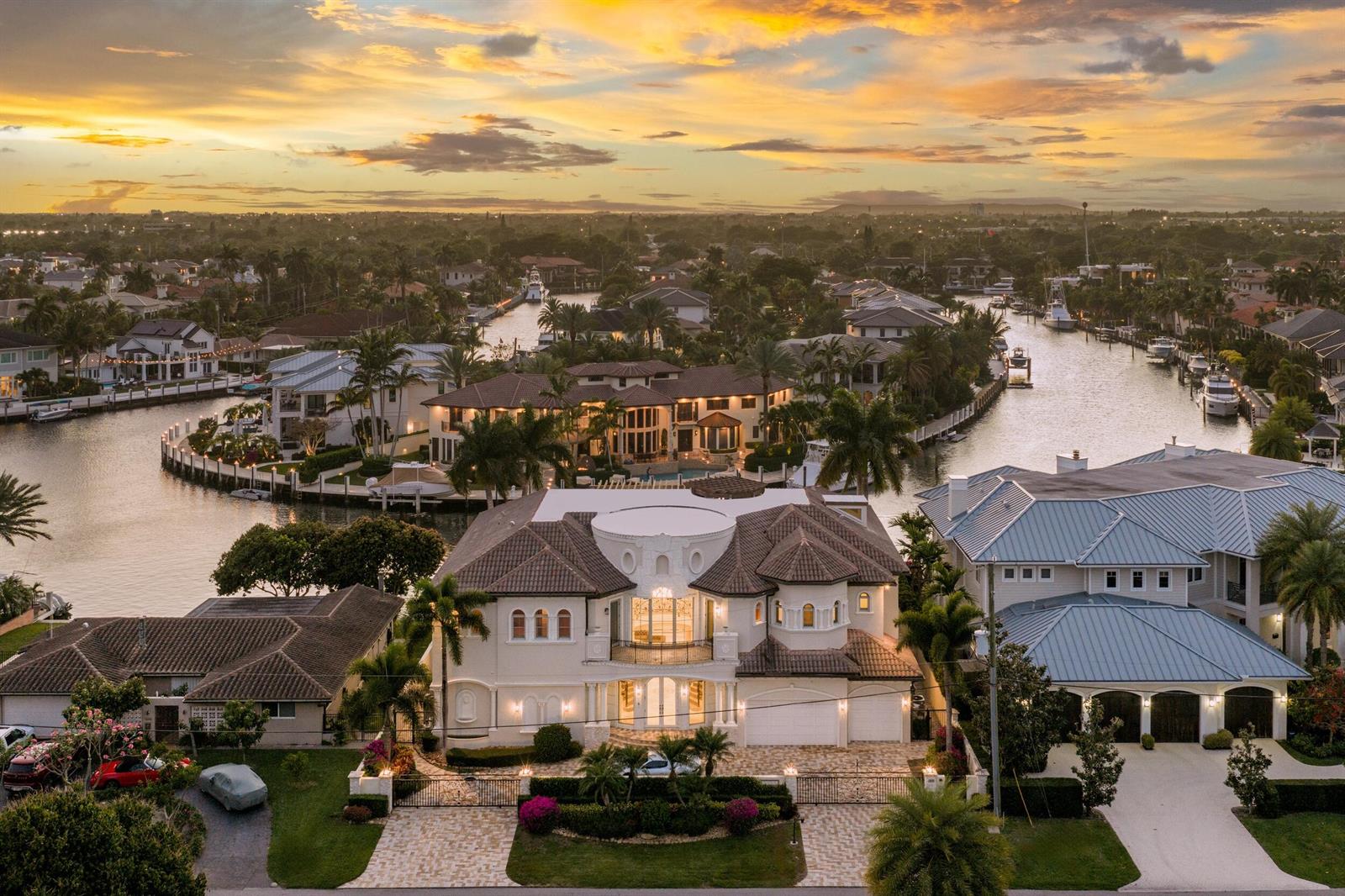 An aerial view of a large waterfront mansion with a circular balcony at sunset — 3201 NE 27th Avenue, Lighthouse Point FL 33064, LIGHTHOUSE POINT, FL