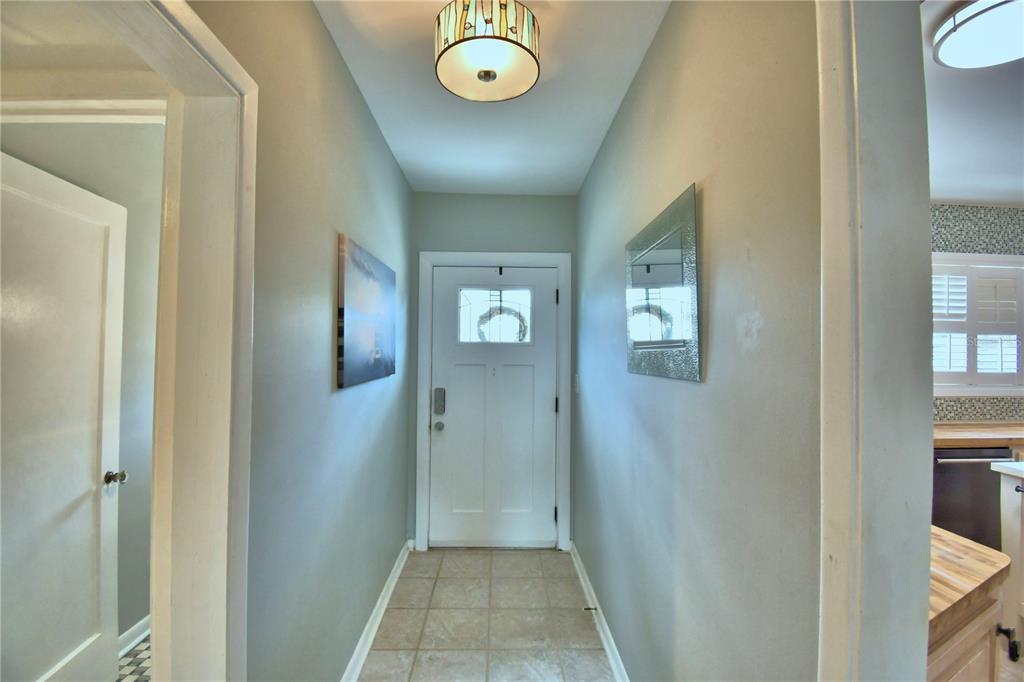 A tiled entryway features a white front door, a ceiling light, and light gray walls — 1620 17TH STREET NW, WINTER HAVEN, FL