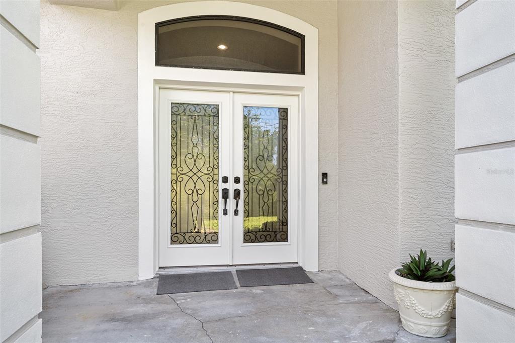 A white double front door with decorative glass inserts and a transom window — 1837 E GLANCY DRIVE, DELTONA, FL