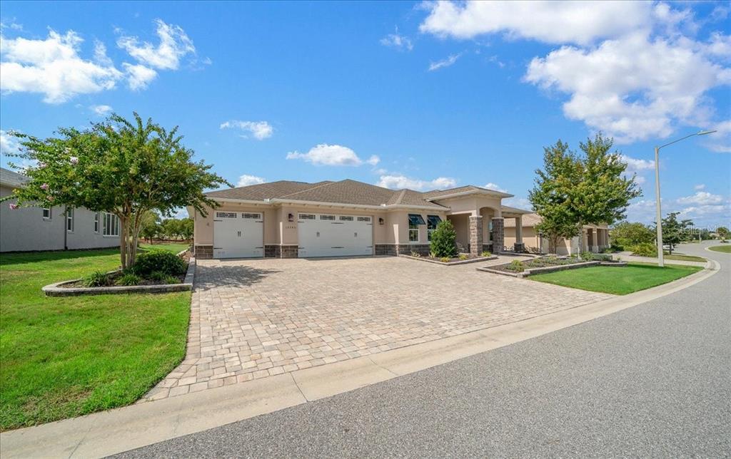 A single-story house with a paved driveway, a three-car garage, and a landscaped front yard — 10346 SW 93RD PLACE, OCALA, FL