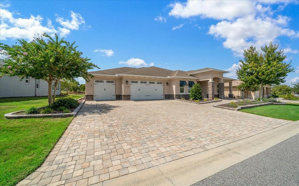 A single-story house with a paved driveway, two-car garage, and landscaped front yard — 10346 SW 93RD PLACE, OCALA, FL