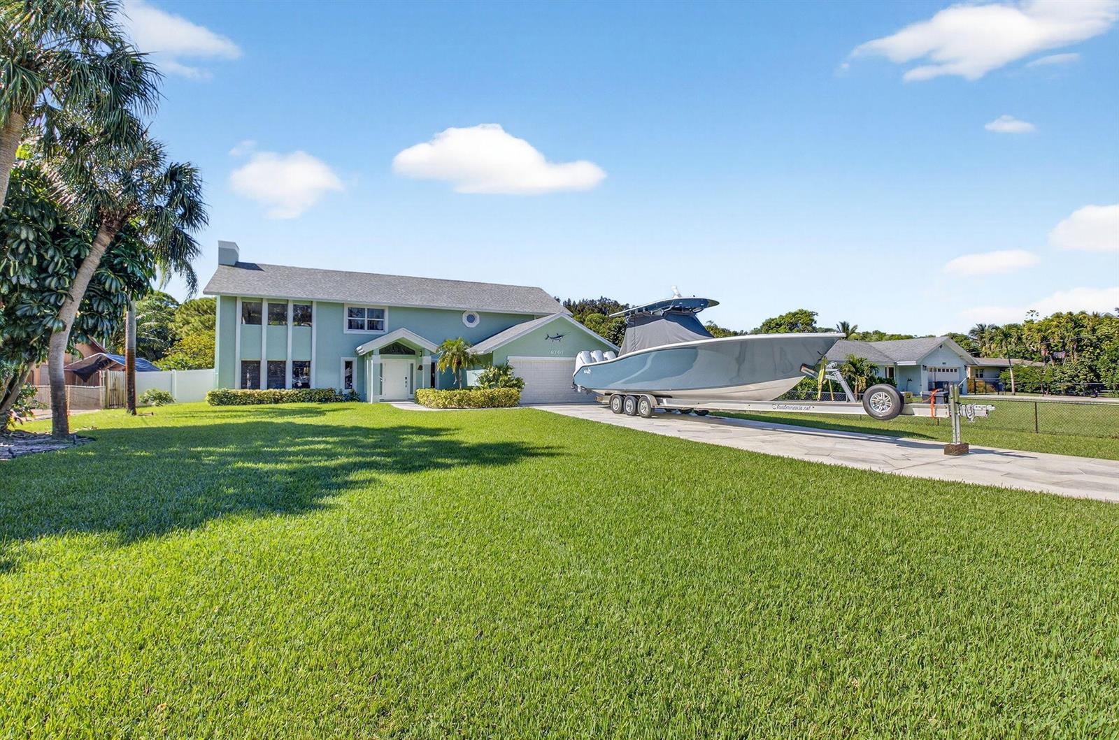 A light green two-story house with a boat on a trailer in the driveway — 6701 Hillside Lane, Lake Worth FL 33462, LAKE WORTH, FL