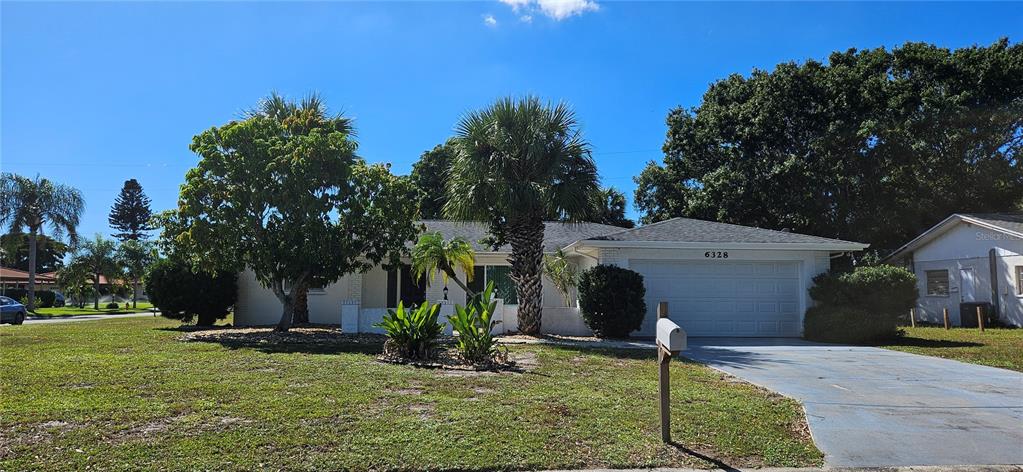 A single-story house with a white brick exterior, a two-car garage, and a palm tree — 6328 GEORGIA AVENUE, BRADENTON, FL