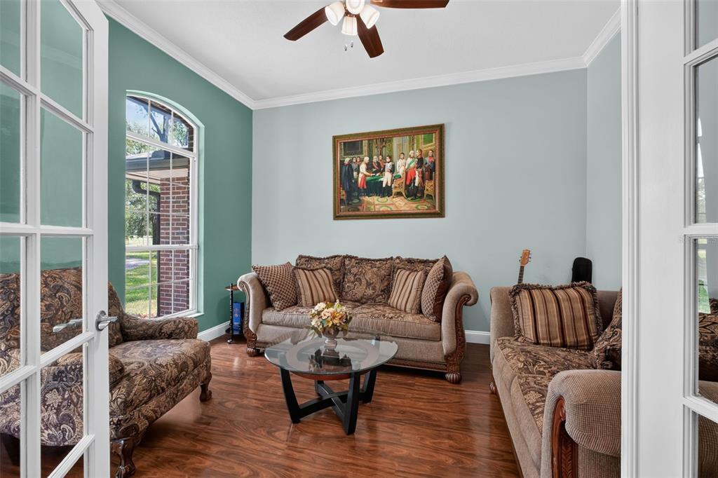 A living room features a teal accent wall, a fireplace, and black leather theater seating — 2527 NW COUNTY ROAD 225, LAWTEY, FL