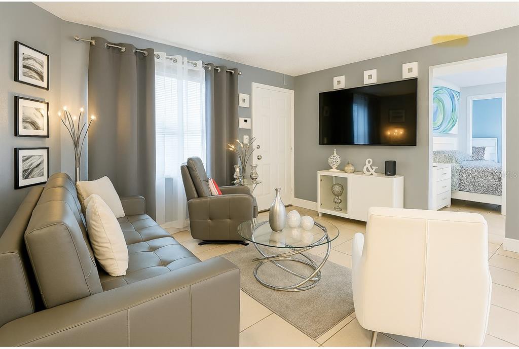 A living room features a gray sofa, a white armchair, a television, and tile flooring — 5294 LANETTE STREET, ORLANDO, FL
